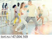 Young woman dances incendiary tango with man partner during choreography lesson. Стоковое фото, фотограф Яков Филимонов / Фотобанк Лори