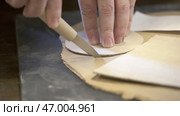 Skillfully Crafting Leather Patterns Utilizing Precision Tools for Exceptional Results. Стоковое фото, фотограф David Kashakhi / Фотобанк Лори