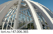 Dome made of metal semi-arches with air space on background of modern city. Стоковое фото, фотограф David Kashakhi / Фотобанк Лори