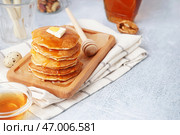 Деревянная доска с вкусными блинами с маслом и кленовым сиропом на белом фоне. Стоковое фото, фотограф Pixel_shot / Фотобанк Лори
