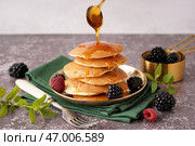 На столе льется кленовый сироп на вкусные блинчики с ягодами. Стоковое фото, фотограф Pixel_shot / Фотобанк Лори