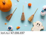 Хэллоуинская композиция с метлами, призраком, глазами и тыквами на голубом фоне. Стоковое фото, фотограф Pixel_shot / Фотобанк Лори