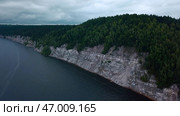 Aerial view of a forested cliff and the large blue lake. Стоковое фото, фотограф David Kashakhi / Фотобанк Лори