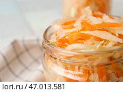 Стеклянная банка с вкусной квашеной капустой на салфетке на фоне плитки. Крупный план. Стоковое фото, фотограф Pixel_shot / Фотобанк Лори