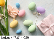 Покрашенные пасхальные яйца с цветами и подарочными коробками на голубом гранжевом фоне. Стоковое фото, фотограф Pixel_shot / Фотобанк Лори