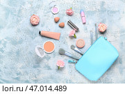 Косметичка с косметическими продуктами и розами на фоне голубого гранжа. Стоковое фото, фотограф Pixel_shot / Фотобанк Лори