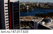 Tall buildings located on the river bank in the city center with overgrown trees. Стоковое фото, фотограф David Kashakhi / Фотобанк Лори