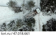 Aerial top view of a crane truck trying to turn around on narrow winter road. Стоковое фото, фотограф David Kashakhi / Фотобанк Лори