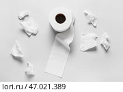 Рулон туалетной бумаги и скомканные простыни на сером фоне. Стоковое фото, фотограф Pixel_shot / Фотобанк Лори