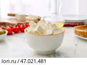 Чаша с кусочками сыра фета на светлом столе на кухне. Стоковое фото, фотограф Pixel_shot / Фотобанк Лори