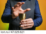 Мужской гадалка с чашкой на цветном фоне, крупным планом. Стоковое фото, фотограф Pixel_shot / Фотобанк Лори