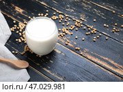 Стакан вкусного соевого молока и ложка на темном деревянном фоне. Стоковое фото, фотограф Pixel_shot / Фотобанк Лори