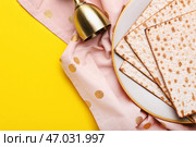 Тарелка с еврейской лепешкой мацей на Пасху и чашкой на цветном фоне. Стоковое фото, фотограф Pixel_shot / Фотобанк Лори