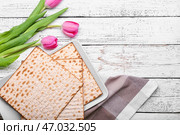 Композиция из еврейских лепешек мацы на Пасху и цветов на деревянном фоне. Стоковое фото, фотограф Pixel_shot / Фотобанк Лори
