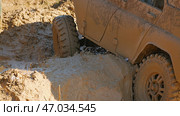 A muddy off-roader sat on the bottom on a complicated racing obstacle course. Close-up of an SUV stuck in the mud. Tires with aggressive tread hanging in the air. Стоковое фото, фотограф Воловодов Владимир / Фотобанк Лори