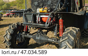 Close-up of a custom-built off-road vehicle with large tires, a powerful engine, and a roll cage. The vehicle is equipped with a winch and other modifications for extreme off-roading. Стоковое фото, фотограф Воловодов Владимир / Фотобанк Лори