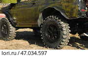 Close-up of an SUV with big studded tires. The vehicle is painted in camouflage color and is ready to go for off-road adventures. Стоковое фото, фотограф Воловодов Владимир / Фотобанк Лори