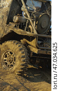 A close-up of a muddy off-road vehicle navigating a challenging sandy terrain. The vehicle's engine, radiator, and cooling fan are visible, suggesting it is built for extreme off-roading. Стоковое фото, фотограф Воловодов Владимир / Фотобанк Лори