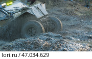 A close-up of a rugged, off-road vehicle splashing through a muddy course during a race. The vehicle has large tires and is partially obscured by mud and water. Стоковое фото, фотограф Воловодов Владимир / Фотобанк Лори