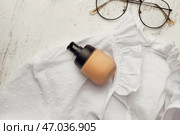 Флакончик основы под макияж и очки на светлом фоне. Стоковое фото, фотограф Pixel_shot / Фотобанк Лори