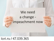 Женщина держит бумагу с текстом НАМ НУЖНЫ ИЗМЕНЕНИЯ - СЕЙЧАС на цветном фоне. Стоковое фото, фотограф Pixel_shot / Фотобанк Лори