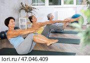 Senior woman performs boat asana - Paripurna navasana. Стоковое фото, фотограф Яков Филимонов / Фотобанк Лори