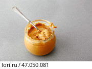 Вкусное арахисовое масло в банке на сером столе. Стоковое фото, фотограф Pixel_shot / Фотобанк Лори