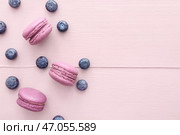 Вкусные макаруны с черникой на цветном деревянном фоне. Стоковое фото, фотограф Pixel_shot / Фотобанк Лори