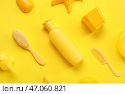 Крем для солнцезащиты для малышей с пляжными принадлежностями на желтом фоне. Стоковое фото, фотограф Pixel_shot / Фотобанк Лори