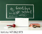 Доска для записей с надписью GOODBYE SCHOOL, рисунками и учительским столом в классе. Стоковое фото, фотограф Pixel_shot / Фотобанк Лори