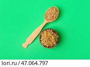 Миска и ложка с пророщенной пшеницей на зеленом фоне. Стоковое фото, фотограф Pixel_shot / Фотобанк Лори