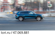 Blue car is driving on empty city asphalt road. Geely Monjaro SUV in motion with blurred background. Редакционное фото, фотограф Константин Григорьев / Фотобанк Лори