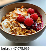 A bowl of healthy and delicious breakfast consisting of yogurt, granola, fresh raspberries, berry sauce and toasted coconut flakes. The golden crunch of the granola is harmoniously combined with the smooth white yogurt, while the deep red berries and thick berry sauce add brightness and freshness. Thin coconut flakes add additional texture and exotic taste. The atmosphere of the photo conveys the coziness of a morning meal filled with health and energy. Стоковое AI-изображение, AI-художник Анна Кривицкая / Фотобанк Лори