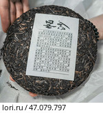 This beautifully crafted Traditional Chinese Puerh Tea Cake has a unique and characteristic label. Стоковое фото, фотограф David Kashakhi / Фотобанк Лори