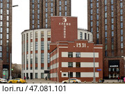 Moscow, Russia, March 14, 2024: Reconstructed 1931 V. P. Zotov Bakery in style of Soviet constructivism (Cultural center "Zotov Center" ) against backdrop of high-rise towers of Presnya City residential complex, Khodynskaya Street. Редакционное фото, фотограф Алексей Антипов / Фотобанк Лори
