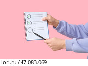 Мужчина держит пустой чекбокс на розовом фоне. Концепция опроса. Стоковое фото, фотограф Pixel_shot / Фотобанк Лори