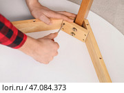 Мужчина-плотник затягивает винт в деревянном столе отверткой, крупный план. Стоковое фото, фотограф Pixel_shot / Фотобанк Лори