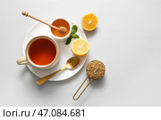 Чашка горячего гречишного чая с лимоном и миска меда на сером фоне. Стоковое фото, фотограф Pixel_shot / Фотобанк Лори