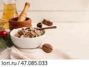 Миска с традиционным украинским кутьей, ветка рождественской елки и кувшин с узваром на белом столе. Стоковое фото, фотограф Pixel_shot / Фотобанк Лори