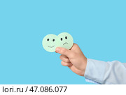 Мужчина держит оценку и улыбается на синем фоне. Концепция опроса. Стоковое фото, фотограф Pixel_shot / Фотобанк Лори