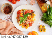 Тарелка вкусной пасты фарфалле с томатами и базиликом на белом фоне. Стоковое фото, фотограф Pixel_shot / Фотобанк Лори
