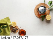 Красивая композиция с чайником, чашкой чая и лимоном на светлом фоне с эффектом состаривания. Стоковое фото, фотограф Pixel_shot / Фотобанк Лори