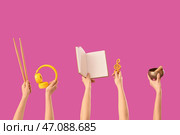 Женские руки держат барабанные палочки с наушниками, блокнотом и тибетской поющей чашей на розовом фоне. Стоковое фото, фотограф Pixel_shot / Фотобанк Лори