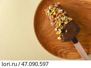 Тарелка с вкусным фисташковым и шоколадным мороженым на цветном фоне. Стоковое фото, фотограф Pixel_shot / Фотобанк Лори