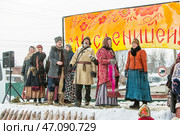 Коллектив в старорусских народных одеждах выступает на уличной сцене. Празднование Масленицы на территории Кафедрального собора в честь Преображения Господня. Бердск, Новосибирская область, Западная Сибирь, Россия. Редакционное фото, фотограф Евгений Мухортов / Фотобанк Лори