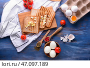 Тарелка с вкусными вареными яйцами и поджаренным хлебом со специями на цветной деревянный стол. Стоковое фото, фотограф Pixel_shot / Фотобанк Лори