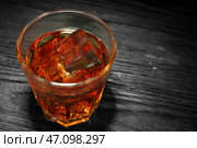 Стакан виски со льдом на деревянном столе, крупным планом. Стоковое фото, фотограф Pixel_shot / Фотобанк Лори
