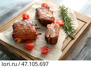 Вкусные ребрышки на гриле с помидорами на деревянной доске. Стоковое фото, фотограф Pixel_shot / Фотобанк Лори