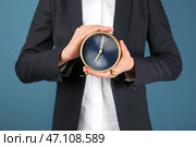 Женщина, держащая часы на цвет фона. Концепция тайм-менеджмента. Стоковое фото, фотограф Pixel_shot / Фотобанк Лори