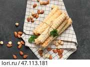 Вкусные вафельные трубочки, орехи и мята на черном гранж-фоне. Стоковое фото, фотограф Pixel_shot / Фотобанк Лори